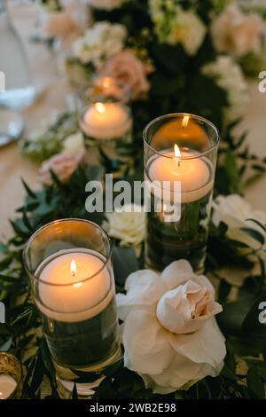 decorazioni con tavoli per ricevimenti nuziali con candele e decorazioni floreali Foto Stock