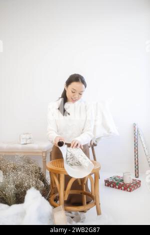 Asiatico ragazza avvolgere regali di natale Foto Stock
