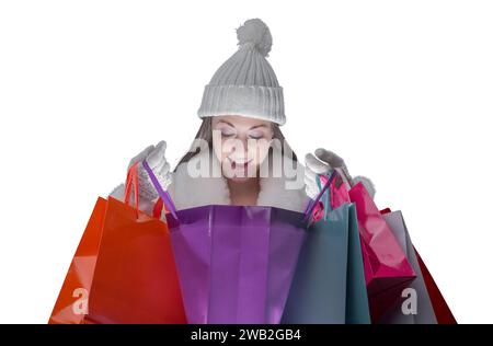 Donna felice che fa shopping di Natale, sta guardando dentro una borsa Foto Stock