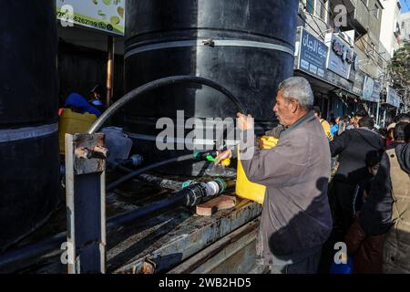 Rafah, territori palestinesi. 8 gennaio 2024. Un palestinese riempie un jerrycan di acqua. Le organizzazioni caritative distribuiscono acqua alle persone colpite dalla guerra a Gaza. Crediti: Abed Rahim Khatib/dpa/Alamy Live News Foto Stock