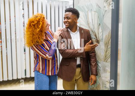 Felice coppia che ha scelto le piastrelle per il loro appartamento. Foto Stock