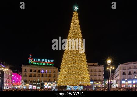 Puerta del Sol, nel cuore della capitale spagnola Madrid, completamente decorata per Natale, con un gigantesco albero pieno di luci e tio pepe Foto Stock