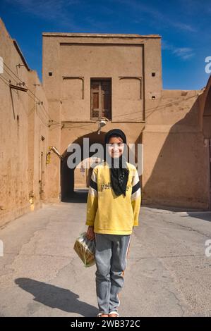 Una ragazza locale amichevole che indossa una Shayla si è offerta di posare per una foto a Yazd, Iran. Un grande sorriso sulla sua faccia Foto Stock