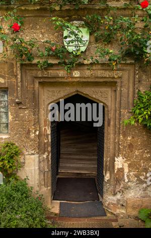 Regno Unito, Inghilterra, Oxfordshire, Oxford, Worcester College, porta del cottage medievale con scudo araldico sopra Foto Stock