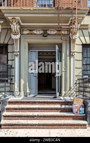 Il 215 East 117th Street è un edificio di appartamenti a sei piani a East Harlem con un mosaico nella parete laterale e dettagli d'ingresso dipinti in oro. Foto Stock