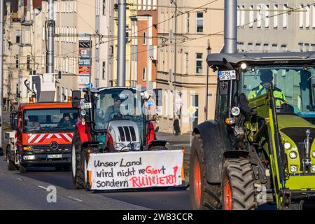 Cottbus, Germania. 8 gennaio 2024. Gli agricoltori guidano i trattori attraverso il centro di Cottbus per una dimostrazione. Protestando contro agricoltori e imprenditori delle aziende di trasporto guidano in una galleria di automobili. Anche altri mestieri, compresi gli artigiani, sostengono le proteste. In risposta ai piani di austerità del governo federale, l'associazione degli agricoltori ha chiesto una settimana di azione con raduni e raduni a partire dall'8 gennaio. Crediti: Frank Hammerschmidt/dpa/Alamy Live News Foto Stock