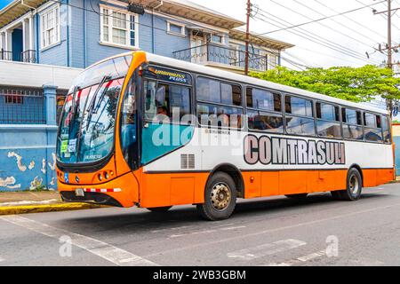 San José Costa Rica 04. Gennaio 2021 autobus colorati nel traffico trafficato e paesaggio urbano con negozi persone e automobili a San José in Costa Rica. Foto Stock