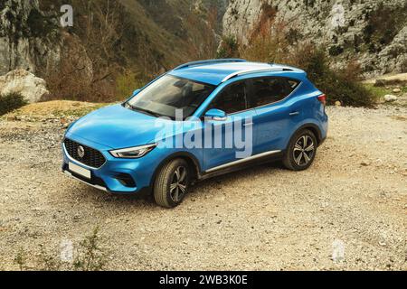 Tirana, Albania - 30 novembre 2023: Una foto che cattura la vista frontale con un leggero angolo laterale sinistro di un SUV blu MG ZS, contro uno sfondo naturale Foto Stock