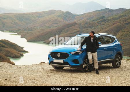 Tirana, Albania - 30 novembre 2023: Una foto raffigurante il SUV MG ZS in blu, scattata da un'angolazione frontale che enfatizza il lato sinistro, con Bovilla Lak Foto Stock