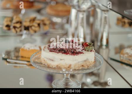 Un assortimento di torte appena fatte esposte su un supporto di vetro Foto Stock