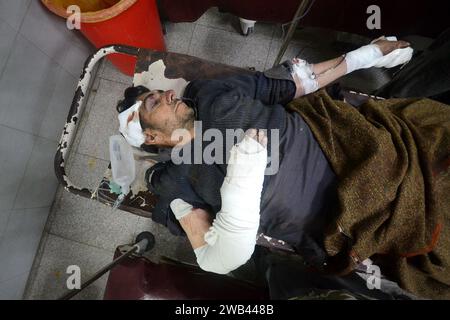 Peshawar, Pakistan. 8 gennaio 2024. Lavoratori e volontari dell'ospedale scaricano un agente di polizia ferito, vittima di un bombardamento stradale, da un'ambulanza all'arrivo in un ospedale di Peshawar, Pakistan. Una bomba è esplosa lunedì vicino a un furgone che trasportava la polizia incaricata di proteggere i lavoratori in una campagna di immunizzazione anti-polio nel ristivo Pakistan nordoccidentale, uccidendo e ferendo ufficiali e altri, hanno detto funzionari. (Immagine di credito: © Hussain Ali/ZUMA Press Wire) SOLO USO EDITORIALE! Non per USO commerciale! Foto Stock