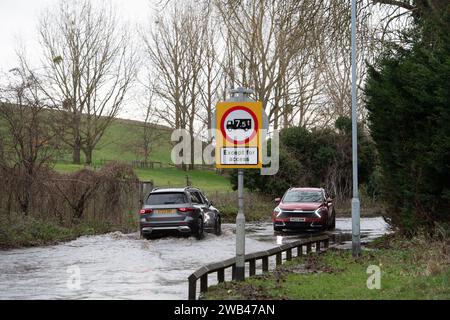 Horton, Wraysbury, Berkshire, Regno Unito. 8 gennaio 2024. Gli automobilisti guidano attraverso le acque alluvionali su una strada di campagna a Horton, Wraysbury, Berkshire. Il Tamigi ha fatto irruzione sulle sue sponde e vi sono una serie di chiusure stradali nell'area locale. Credito: Maureen McLean/Alamy Live News Foto Stock