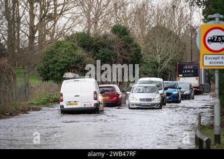 Horton, Wraysbury, Berkshire, Regno Unito. 8 gennaio 2024. Gli automobilisti guidano attraverso le acque alluvionali su una strada di campagna a Horton, Wraysbury, Berkshire. Il Tamigi ha fatto irruzione sulle sue sponde e vi sono una serie di chiusure stradali nell'area locale. Credito: Maureen McLean/Alamy Live News Foto Stock