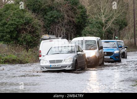 Horton, Wraysbury, Berkshire, Regno Unito. 8 gennaio 2024. Gli automobilisti guidano attraverso le acque alluvionali su una strada di campagna a Horton, Wraysbury, Berkshire. Il Tamigi ha fatto irruzione sulle sue sponde e vi sono una serie di chiusure stradali nell'area locale. Credito: Maureen McLean/Alamy Live News Foto Stock