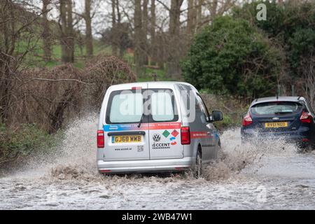 Horton, Wraysbury, Berkshire, Regno Unito. 8 gennaio 2024. Gli automobilisti guidano attraverso le acque alluvionali su una strada di campagna a Horton, Wraysbury, Berkshire. Il Tamigi ha fatto irruzione sulle sue sponde e vi sono una serie di chiusure stradali nell'area locale. Credito: Maureen McLean/Alamy Live News Foto Stock