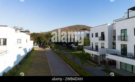 Marciapiede e aree verdi circondate da case bianche vista aerea dell'area comune nella città dell'eterna primavera di Morelos Messico Foto Stock