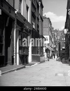 1950, storico vicolo lastricato a Shepherd Market, Mayfair, Londra, Inghilterra, Regno Unito. Un'affascinante piazza del XVIII secolo con negozi indipendenti, pub e ristoranti tra Piccadilly e Curzon Street nel West End di Londra, Shepherd Markert fu costruito tra il 1735 e il 1746 dal suo architetto e sviluppatore, Edward Shepherd, una figura di spicco del suo tempo. Foto Stock