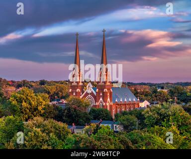 Una vista aerea di uno splendido tramonto su una pittoresca chiesa circondata da una vegetazione lussureggiante Foto Stock