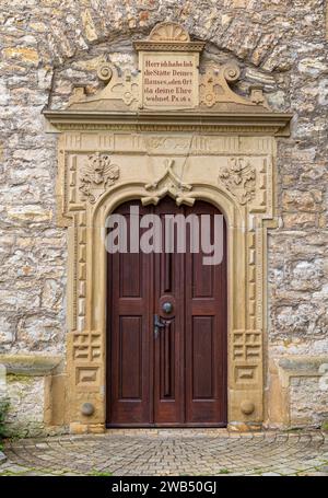 Circondati in pietra da elementi decorativi e iscrizioni bibliche in lingua tedesca sulla porta d'ingresso del sebastianskirche a Kochendorf, Bad Friedrich Foto Stock