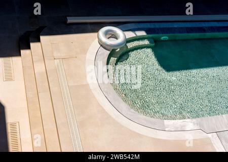 Vista dall'alto della piscina con ciambella gonfiabile. Estate di ritorno. Foto Stock