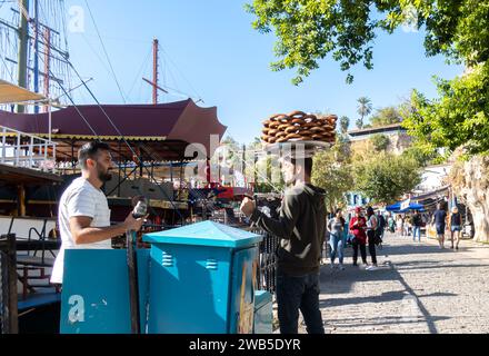 Uomo turco che porta simit sul vassoio sulla testa - anelli turchi di pane al sesamo nella strada di Antalya in Turchia Foto Stock