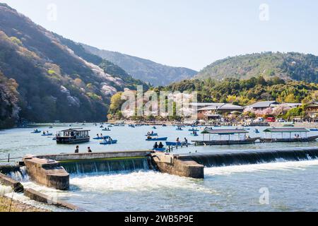 Fiori di ciliegio nel distretto di Arashiyama. Noleggio barche sul fiume Katsura (fiume Oi). Kyoto, Giappone Foto Stock