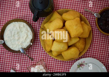 Un'invitante vista dall'alto in basso cattura una deliziosa colazione a buffet, con pane appena sfornato, deliziosa marmellata e una confortevole tazza di te', un semplice Foto Stock