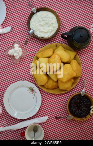 Un'invitante vista dall'alto in basso cattura una deliziosa colazione a buffet, con pane appena sfornato, deliziosa marmellata e una confortevole tazza di te', un semplice Foto Stock