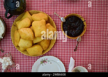 Un'invitante vista dall'alto in basso cattura una deliziosa colazione a buffet, con pane appena sfornato, deliziosa marmellata e una confortevole tazza di te', un semplice Foto Stock