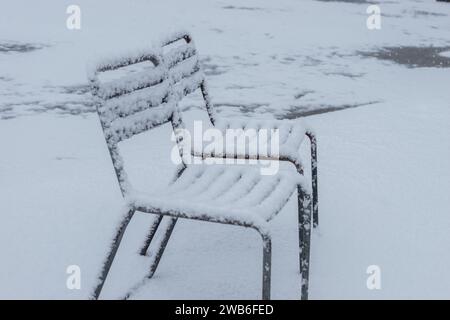 San Gallo, Svizzera, 28 novembre 2023 neve fresca sta cadendo sulle sedie nell'orto botanico Foto Stock