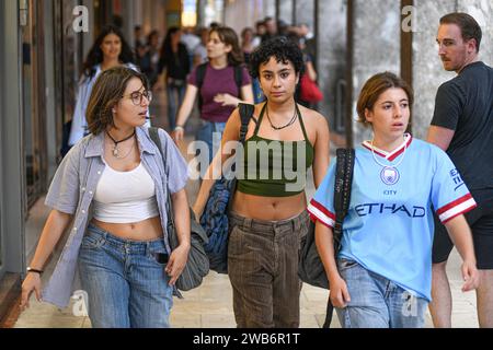 Giovani donne italiane che camminano in via Ugo Bassi, con un uomo che le guarda. Bologna, Italia. Foto Stock