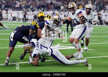 Houston, Stati Uniti. 8 gennaio 2024. Il quarterback dei Washington Huskies Michael Penix Jr. Viene placcato vicino alla linea di goal dalla difesa dei Michigan Wolverines nel secondo quarto durante il College Football Playoff National Championship 2024 all'NRG Stadium di Houston, Texas, lunedì 8 gennaio 2024. Foto di Kevin M. Cox/UPI Credit: UPI/Alamy Live News Foto Stock