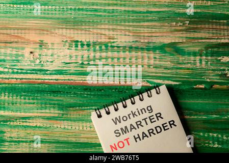 Notebook con testo Working Smarter non Harder su un tavolo in legno. Concetto di gestione delle risorse umane Foto Stock