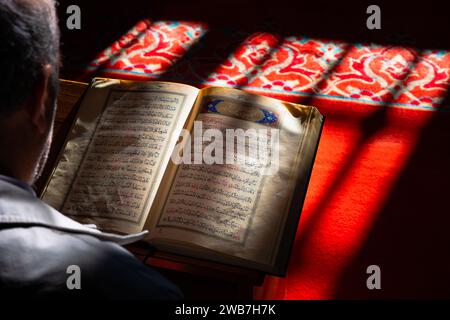 Foto di concetto Ramadan o islamica. L'uomo musulmano legge il Sacro Corano in una moschea. Istanbul Turkiye - 12.29.2023 Foto Stock