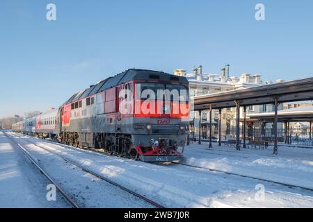 RYBINSK, RUSSIA - 3 GENNAIO 2024: Locomotiva diesel TEP70 con treno passeggeri alla stazione di Rybinsk in un gelido giorno di gennaio Foto Stock