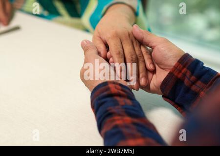 Uomo anziano che tiene per mano il suo partner quando confessa l'amore Foto Stock
