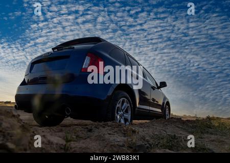 Dubai, Emirati Arabi Uniti, 7 gennaio 2024. Auto Ford Edge 4x4 di colore blu parcheggiata nel deserto. Foto Stock