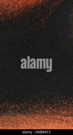 Grana colore. Polvere di glitter. Sfocatura marrone/nero particelle di colore cornice di vernice movimento a onda di gocciolamento sfondo artistico astratto scuro. Foto Stock