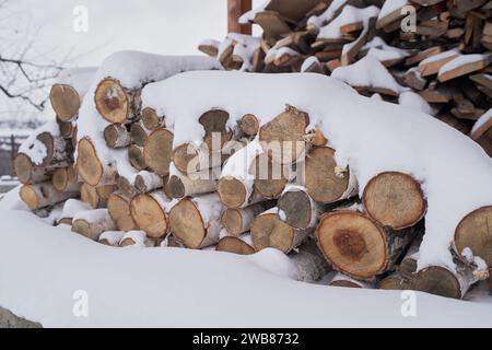 La legna da ardere viene immagazzinata sotto la neve per riscaldare la casa in inverno Foto Stock