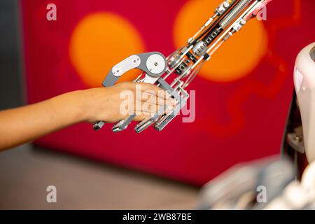 Il ragazzo stringe una mano con un robot, primo piano Foto Stock