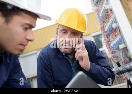 due elettricisti testano gli impianti elettrici Foto Stock