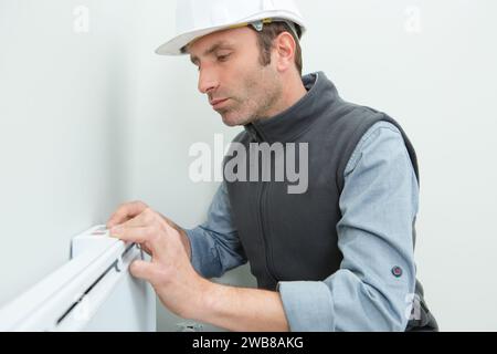 il tuttofare ripara il radiatore Foto Stock