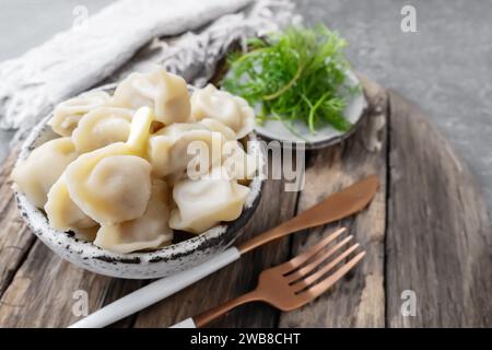 Gnocchi fatti in casa con carne in una ciotola di argilla fatta a mano su uno sfondo di legno chiaro. Primo piano, spazio di copia. Foto Stock