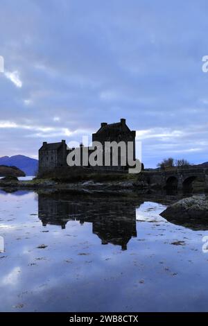 Vista al tramonto sul castello di Eilean Donan, sul villaggio di Dornie, su Kyle of Lochalsh, Wester Ross, Scozia, REGNO UNITO Foto Stock