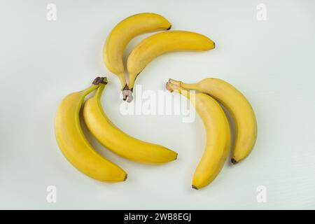 Banane tre per due su sfondo bianco Foto Stock