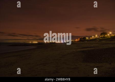 Molo di Clacton illuminato sotto il cielo notturno mentre il sole tramonta Clacton on Sea, Essex Inghilterra Regno Unito. Dicembre 2023 Foto Stock