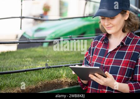 Il contadino controlla il sistema di irrigazione a goccia con tablet digitale Foto Stock