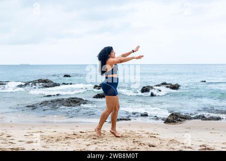 Fitness Woman, atleta, che fa salti sulla sabbia della spiaggia. Stile di vita sano. Foto Stock