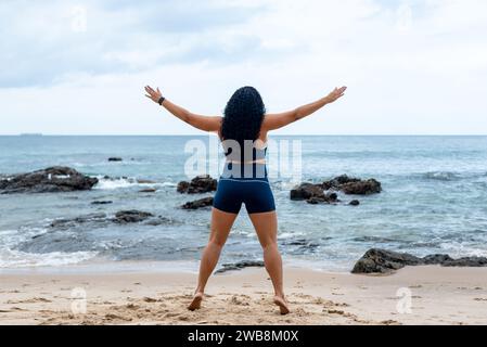 Fitness Woman, atleta, che fa salti sulla sabbia della spiaggia. Stile di vita sano. Foto Stock