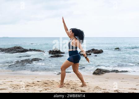 Fitness Woman, atleta, che fa salti sulla sabbia della spiaggia. Stile di vita sano. Foto Stock